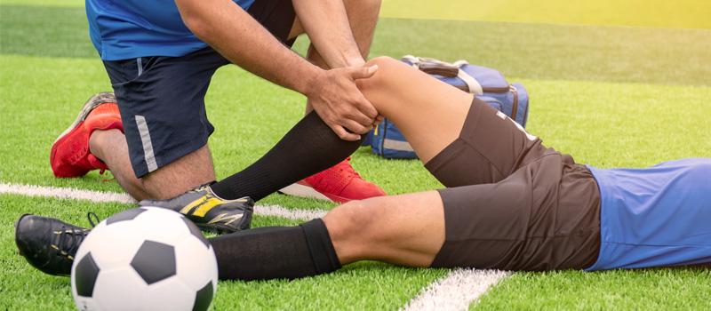 一名膝盖受伤的足球运动员躺在场上